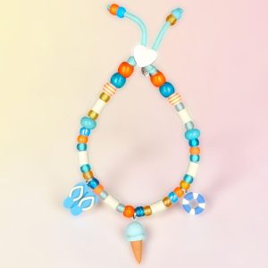 Collier plage pour chien Hondartza en perles céramiques EM, création artisanale PEPS4PETS®, avec perles bleu lagon, turquoise, blanches et orange, perles phosphorescentes, paracorde phosphorescente de 4 mm, breloques tongs, glace et bouée, fabriqué à la main à Bayonne.