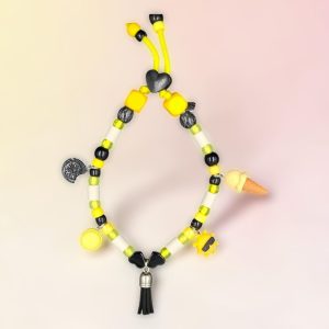 Collier phosphorescent pour chien Eguzki Beltza en perles céramiques EM, création artisanale PEPS4PETS®, avec perles noires et jaunes, perles phosphorescentes entourant les perles céramiques EM, monté sur une paracorde de 4 mm, breloques soleil, glace et biscuit, pompon noir, fabriqué à la main à Bayonne.