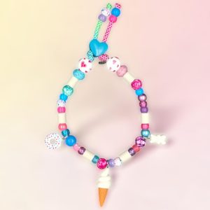 Collier gourmand pour chien Jalkikeria en perles céramiques EM, création artisanale PEPS4PETS®, avec perles roses, bleues, violettes et blanches, breloques glace, donut et petit nounours, monté sur une paracorde de 4 mm et fabriqué à la main à Bayonne.