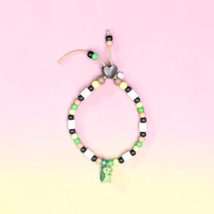 Collier dinosaure pour chien Dino en perles céramiques EM, création artisanale PEPS4PETS®, avec pendentif dinosaure, cœur noir, nuances de noir, blanc, vert anis, vert pastel et beige, monté sur une paracorde de 2 mm et fabriqué à la main à Bayonne.